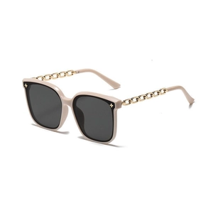 Detail of beige oversized sunglasses featuring gold chain temples and star accents