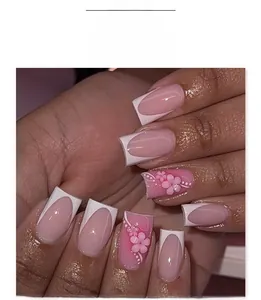 Detail of French white tip press-on nails with 3D pink floral relief and white polka dots