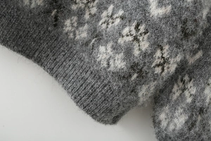 Macro shot of grey snowflake jacquard knit fabric with soft brushed mohair texture