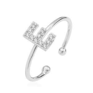 Macro detail of silver letter E ring with cubic zirconia stones and open band