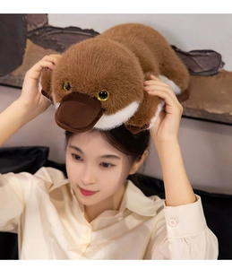Brown platypus plush toy with realistic beak being held overhead by a model