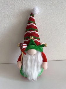 Close-up of a Christmas gnome plush with striped hat, bells and a red candy cane