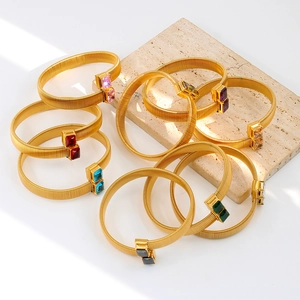 Gouden elastische slangarmbanden met kleurrijke rechthoekige zirkonia-stenen