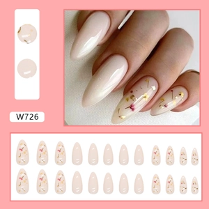 Almond-shaped press-on nails featuring real dried flowers and gold foil accents in soft pink