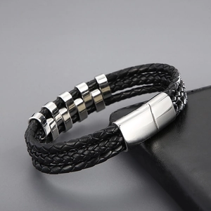 Macro detail of men's multi-layer woven leather bracelet with polished stainless steel clasp