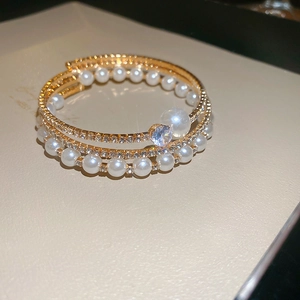 Gros plan du bracelet doré multicouche avec perles raffinées et strass étincelants