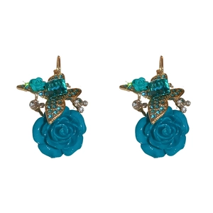 Boucles d'oreilles rose bleue vintage avec accents dorés et cristaux sur fond blanc