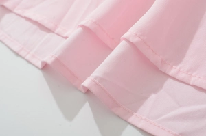 Close-up of double-stitched hem and fabric texture of a pink French retro dress