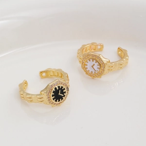Detailed close-up of gold watch-style rings with black and white dials and crystals