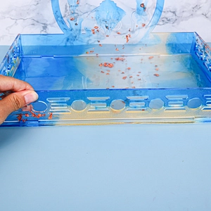 Detail of blue marble acrylic tray with gold foil flakes and geometric cut-out edges