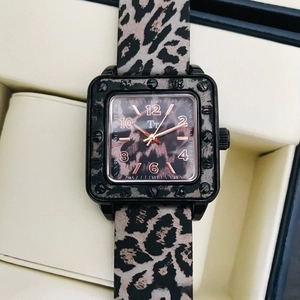 Macro shot of square leopard print watch dial with rose gold hands and matte black case