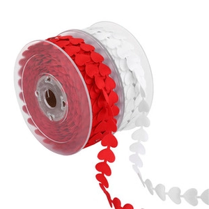 Detail of red and white heart-shaped lace ribbons wound on transparent spools for DIY decor