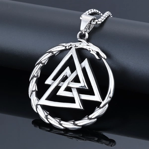 Macro view of silver Viking Valknut pendant with hollow dragon motif on black stand