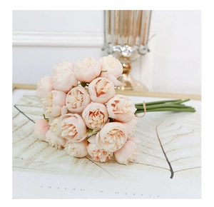 Close-up of light pink faux peony bouquet with silk flower heads on paper
