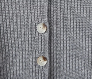 Détail du cardigan en maille grise avec boutons marbrés et texture à côtes fines