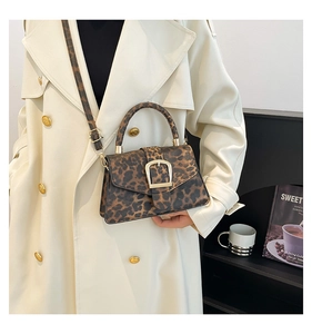 Detail of vintage leopard print crossbody bag with gold buckle on a lifestyle background