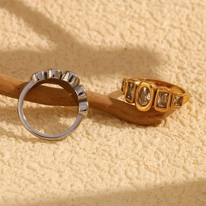 Close-up of gold and silver rings with geometric zircons on a decorative branch