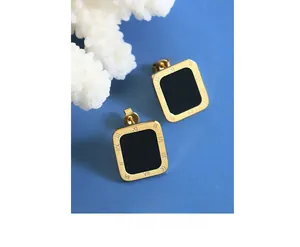 Macro detail of French vintage square earrings with Roman numerals on a blue background