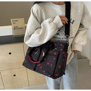 Detail of printed tote bag showing multi-pocket design and adjustable shoulder straps