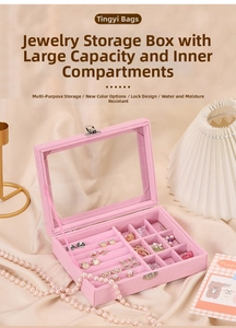 Pink velvet jewelry box with transparent lid showing rings and earrings storage slots