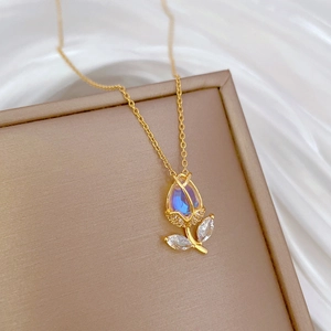 Golden tulip necklace with moonstone and zircon pendant on a champagne gift box