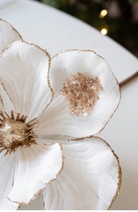 Macro detail of white velvet faux orchid with gold glitter edges and sequin center petals