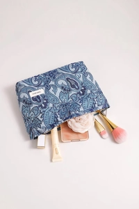 Detail of blue paisley cosmetic bag showing zipper closure and interior storage space