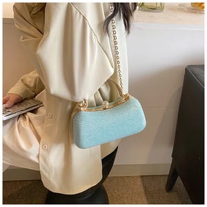 Detail of light blue glitter clutch bag with golden chain and diamond clasp