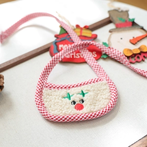 Detail view of a reindeer embroidery on a plaid trim fleece Christmas pet bandana
