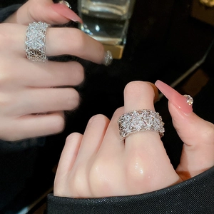 Detailed view of silver lace hollow ring with sparkling pavé zircons on finger