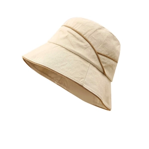 Detail of beige cotton bucket hat featuring brown piping and unique layered texture