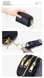 Detailed view of black pebble leather coin purse with three gold zippers and key ring
