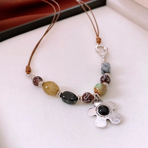 Detailed close-up of retro resin beaded necklace featuring a silver flower pendant on cord