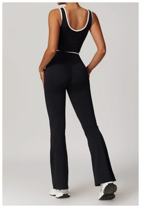 Back view of black yoga vest with white contrast trim and flared leggings set