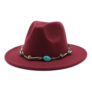 Detail of burgundy fedora hat featuring turquoise stones and gold metal chain band