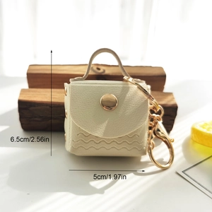 Creamy white PU leather mini bag keychain with wavy stitching and dimension annotations