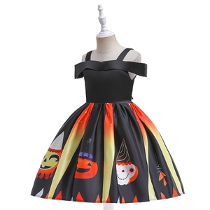 Detail of Halloween girl dress featuring pumpkin and wizard hat patterns on satin skirt