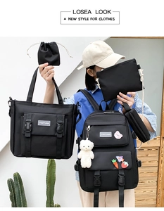 Detail of five-piece black canvas backpack set including tote and pencil case with bear charm