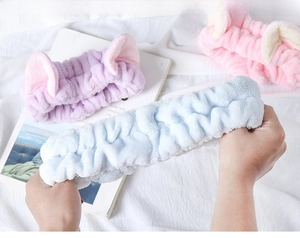 Detailed view of elastic cat ear headbands showing high stretch and soft coral fleece texture
