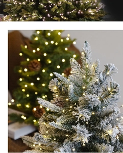 Detail of flocked Christmas tree with warm LED string lights and natural pinecones