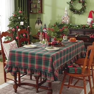 Detail view of a Christmas red and green plaid tablecloth with ruffle pleated skirt edges