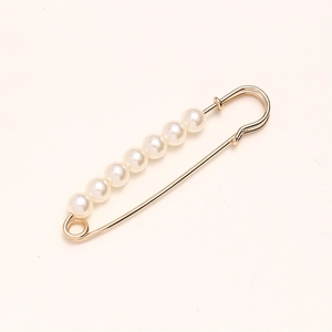 Golden waist pin with seven white pearls for adjusting dress waistline and clothing closure