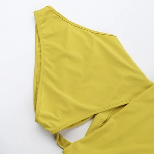 Detailed close-up of ginger yellow bodycon dress showing one-shoulder and waist cut-out