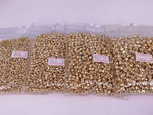 Detailed view of faceted 18K gold-plated beads in various sizes for DIY jewelry making