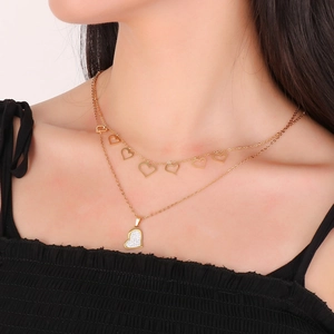 Close-up of double layer heart pendant necklace in gold finish on female neck