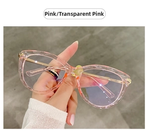 Montatura per occhiali cat eye rosa trasparente con cerniera in metallo in mano