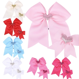 Flat lay of colorful swallowtail bow hair clips with glittery heart center accents
