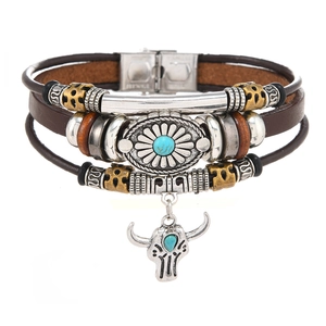 Detail of multilayer brown leather bracelet with turquoise sunflower and bull head pendant