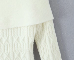 Detailed close-up of white cable knit fabric texture on this off-shoulder long sleeve dress