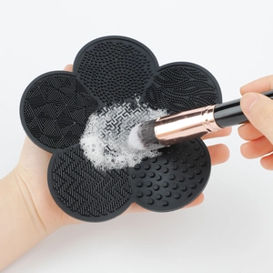 Detail of flower-shaped silicone makeup brush cleaning mat with foam and textured surface